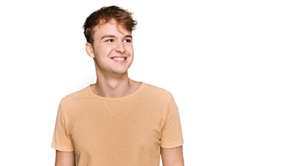 Fototapeta premium Young caucasian man wearing casual clothes looking away to side with smile on face, natural expression. laughing confident.