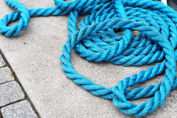 blue yacht mooring line lies on the pier