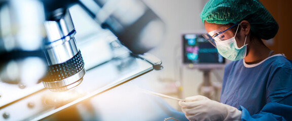 Scientist or doctor working in the operating room with microscope and glassware, medical and...