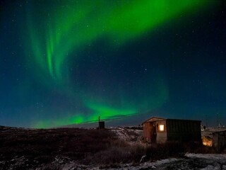 Fototapeta na wymiar Old weather station. Winter Teriberka. Evening polar landscape with the Aurora Borealis.
