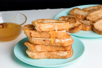 homemade French toast fried with honey on a blue plate on a dark background. soaked in milk egg mixture. healthy breakfast