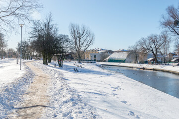 Fototapeta na wymiar Snowy view on pathway on Radunia river in Pruszcz Gdanski, Poland.