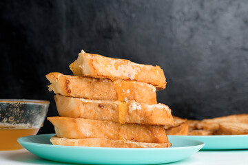 homemade French toast fried with honey on a blue plate on a dark background. soaked in milk egg mixture. healthy breakfast