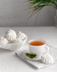A cup of tea with sweet marshmallows. Delicious breakfast in a high key