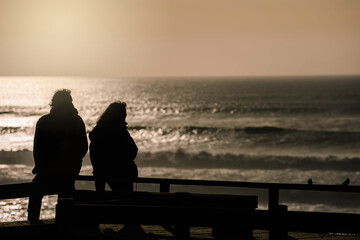 middle-aged couple watching the sunset over the ocean