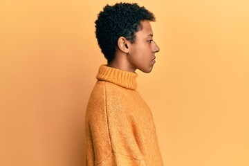 Young african american girl wearing casual clothes looking to side, relax profile pose with natural face with confident smile.