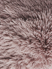 Close-up view of fluffy pillow. Pastel pink cozy background texture.