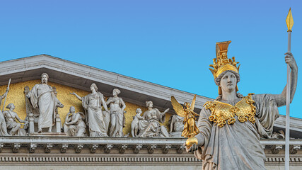 Obraz premium Athena statue at fountain (Pallas-Athene-Brunnen) in front of the Parliament, an ancient Greek goddess for victory and warfare at blue sky in Vienna, Austria, details, closeup.
