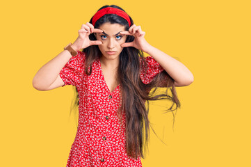 Brunette teenager girl wearing summer dress trying to open eyes with fingers, sleepy and tired for morning fatigue