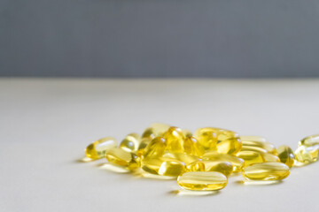 Yellow capsules are scattered on a light background.Soft focus.