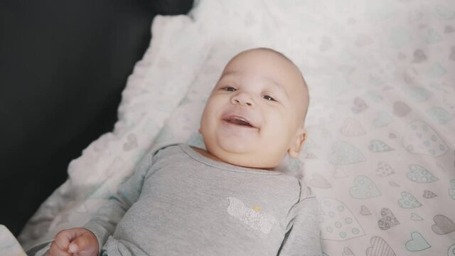 Portrait of cute baby smiling in the crib. High quality 4k footage