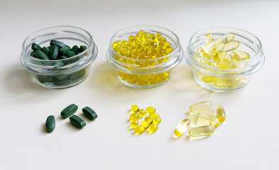 Close-up of dietary supplements: natural omega-3 in gel capsules, vitamin D3, chlorella. The health trio.Prevention of diseases and support of immunity.