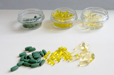 Close-up of dietary supplements: natural omega-3 in gel capsules, vitamin D3, chlorella. The health trio.Prevention of diseases and support of immunity.