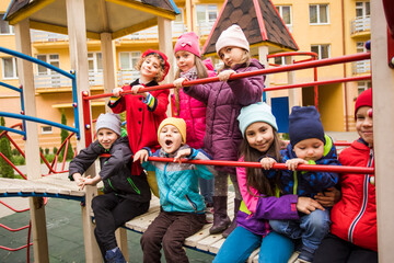 Fototapeta na wymiar the smiling kids are standing together on the playground equipment