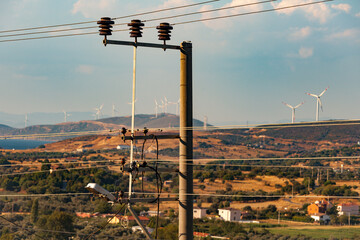 concept idea eco power energy. wind turbine on hill with blue sky and the electric lines are...