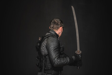 Futuristic sci fi soldier with Katana sword on a black background.