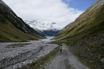 Fototapeta na wymiar a woman hiking at the Schlegeis Stausee in the High Alps Nature Park, Zillertal Alps, Tirol, Austria, September