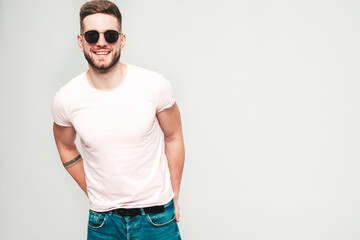 Portrait of handsome smiling stylish hipster lambersexual model.Man dressed in white T-shirt and...