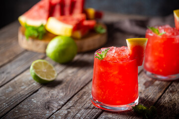 Refreshing cold summer watermelon drink in glasses with slices of watermelon and lime