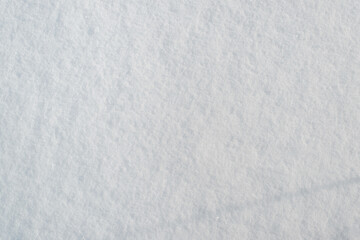 Snow surface texture, sunny winter day outside. Snow background, soft focus. Top view, copy space