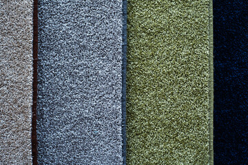 Samples of carpets on the counter in the store. Sale of floor coverings made of artificial...