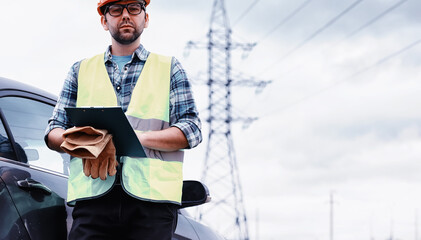 A man in a helmet and uniform, an electrician in the field. Professional electrician engineer...