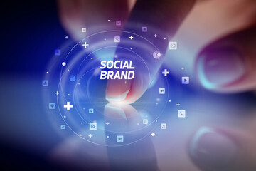 Finger touching tablet with social media icons and SOCIAL BRAND