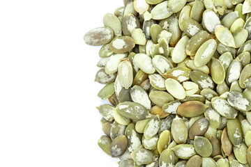 Close-up background texture of green pumpkin seeds on a white background. Space for text.