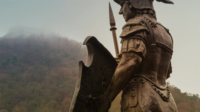 Low angle view of pedestrian statue of roman soldier and the medieval fortress Deva in Transylvania.
