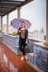 girl walking with an umbrella. spring rainy days and walks. city of lisbon. travel and walks through beautiful places