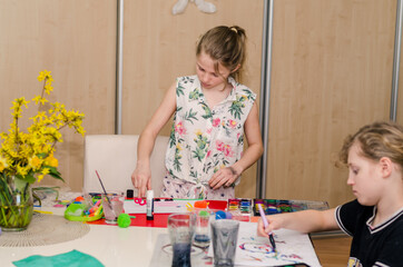 Easter atmosphere at home with children creating Easter craft and colorful decorations