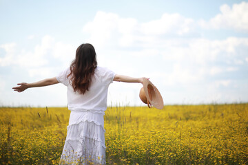 Pregnant woman in a dress in a field of flowers