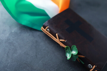 A leather-bound Bible on the table. Religious Christian Irish celebration. Four-leaf clover symbol of good luck.