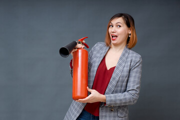 A woman with red hair in the Studio holding a fire extinguisher. An emotional bright woman extinguishes everything with a fire extinguisher.