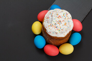 Easter cake and colorful Easter eggs in black background.