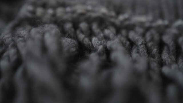 Macro shot of woolen fabric. Extreme close-up of clothing material gray fabric texture. Woollens, woolens, wool fibers. Warm winter clothing. 