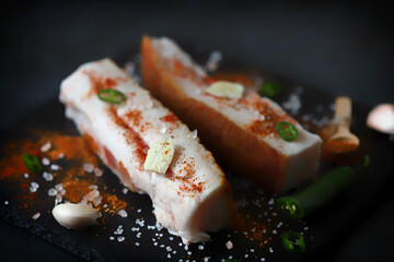 Lard with spices on a stone board. Salting lard. Gammoning.
