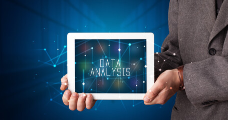 Young business person working on tablet and shows the digital sign: DATA ANALYSIS