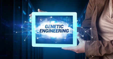 Young business person working on tablet and shows the inscription: GENETIC ENGINEERING