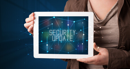 Young business person working on tablet and shows the digital sign: SECURITY UPDATE