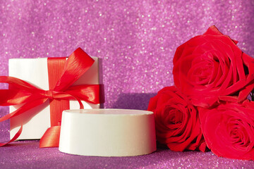 gift box with a red bow, three red roses and a podium on a purple glittering background..