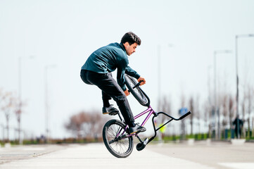 Young man performing tricks with a flatland bmx bike