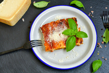 Cannelloni bolognese and parmesan cheese  on a wooden rustic  background.Home made italian meal
