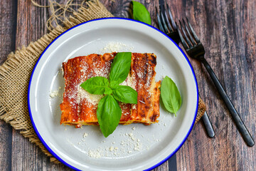 Cannelloni bolognese and parmesan cheese  on a wooden rustic  background.Home made italian meal
