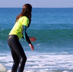 Girl practicing a water sport such as surfing, enjoying a physical activity outdoors