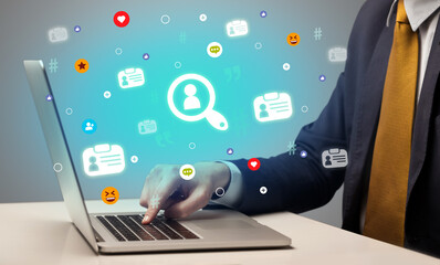 Hand surfing on the social media with lookup icons coming out from the screen, networking concept