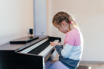 Little girl learning to play electric piano
