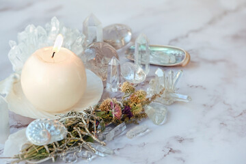 quartz minerals, floral cleansing bundle and candle on marble background. spiritual Crystal Ritual,...