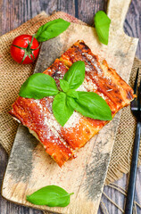 Cannelloni bolognese and parmesan cheese  on a wooden rustic  background.Home made italian meal
