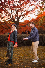 Obraz premium Man and woman. Autumn. Park. A man catches a falling woman